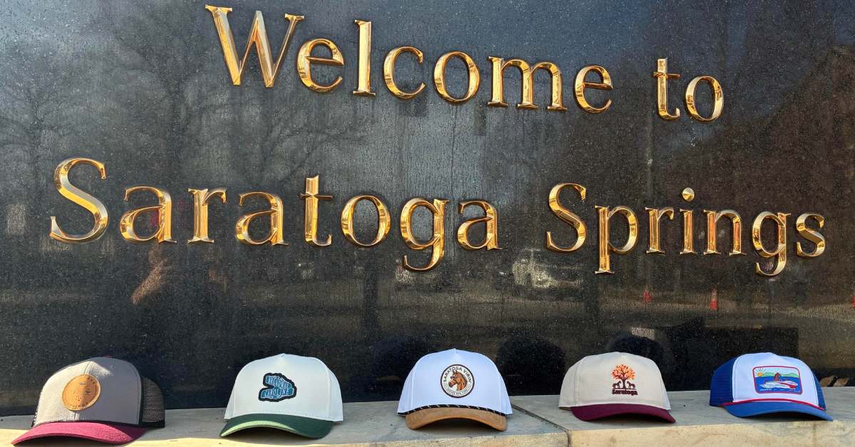 welcome to saratoga springs sign and row of hats