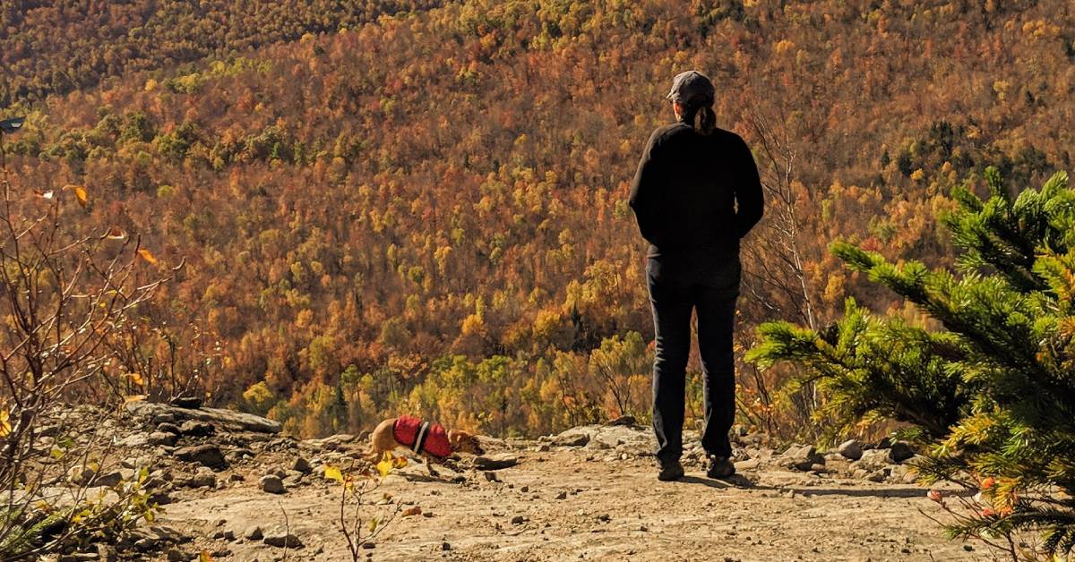 woman with small dog at summit