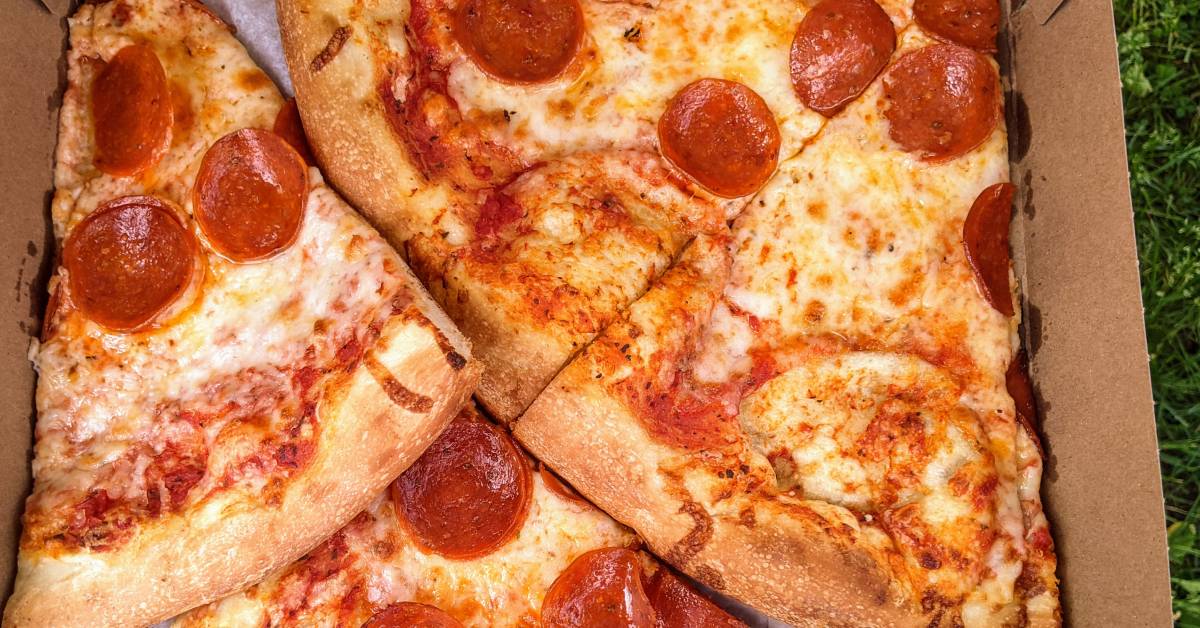 pizza in box on grass