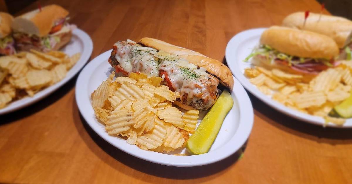 plated subs and sandwiches with chips and pickle