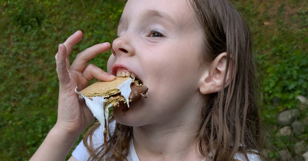 little girl eating s'mores