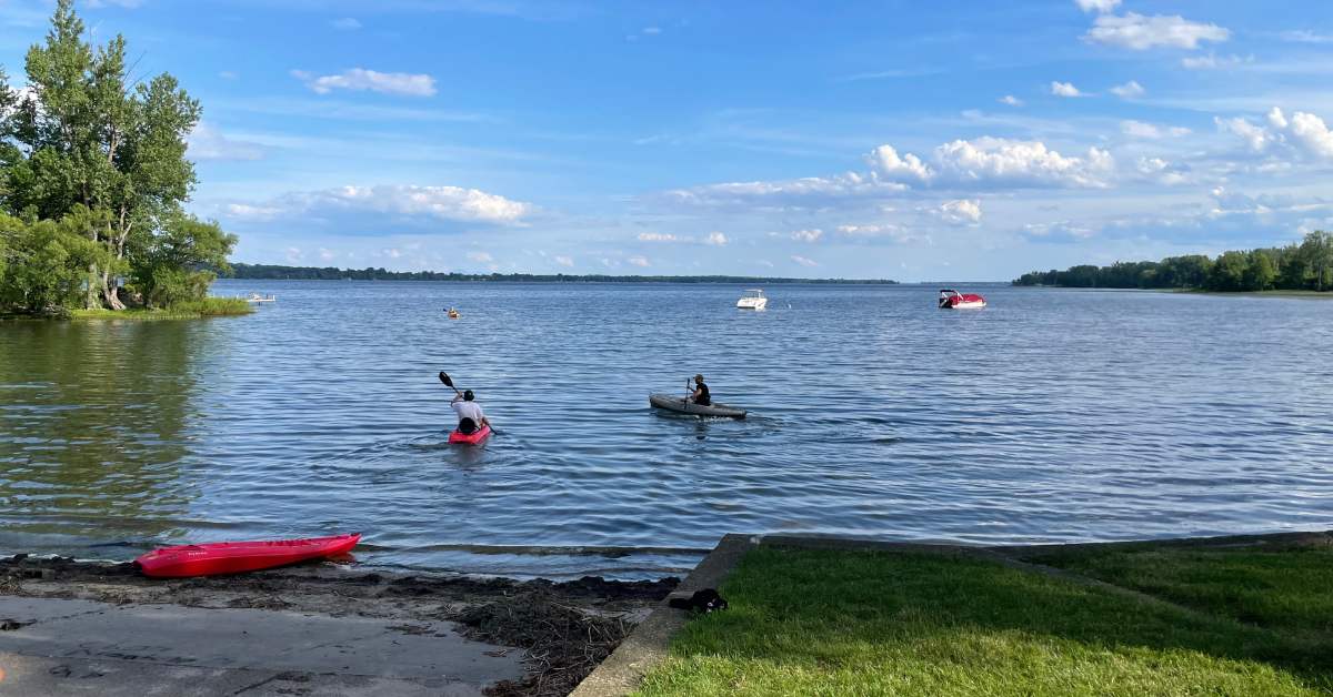people heading out onto a lake in kayaks