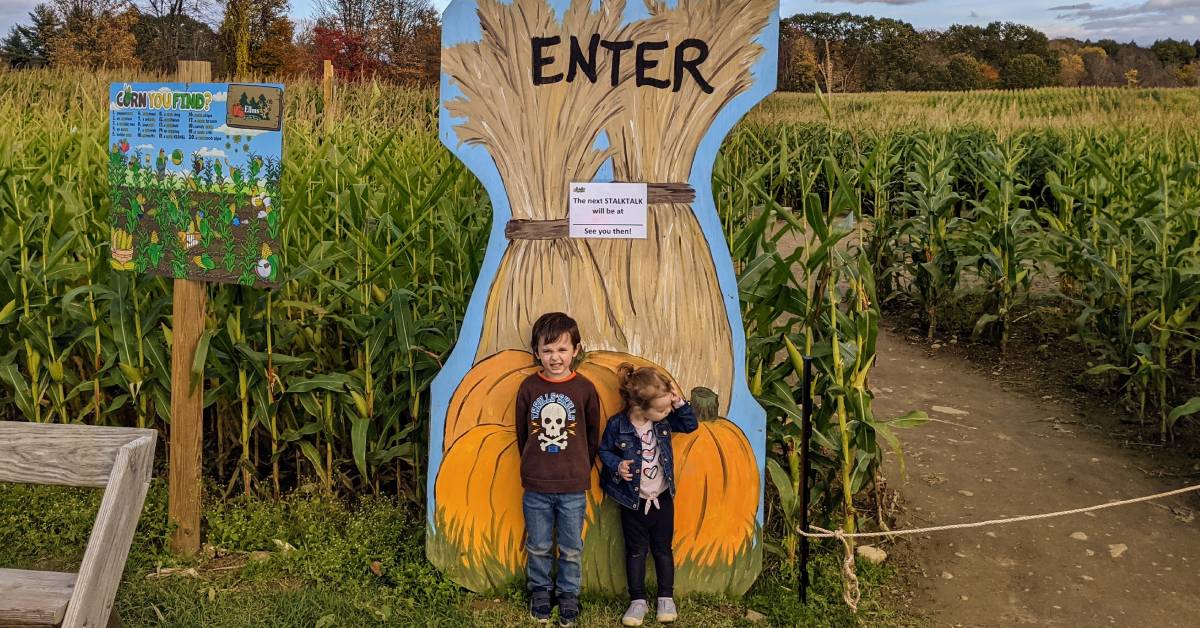 kids by corn maze sign