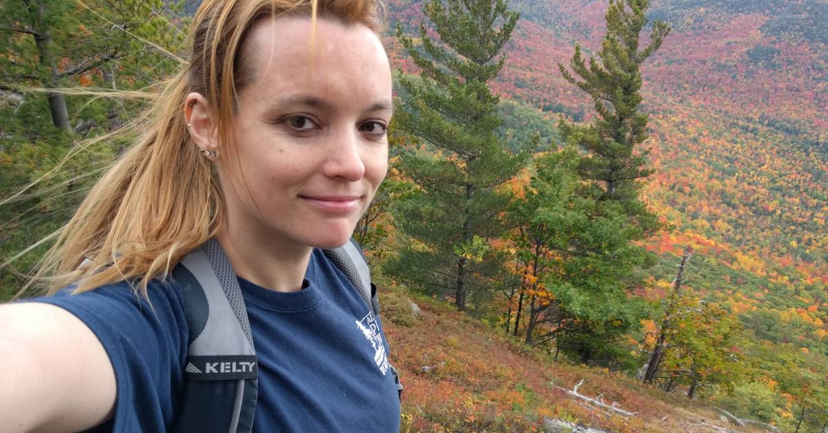 solo hike takes selfie on mountain summit during fall