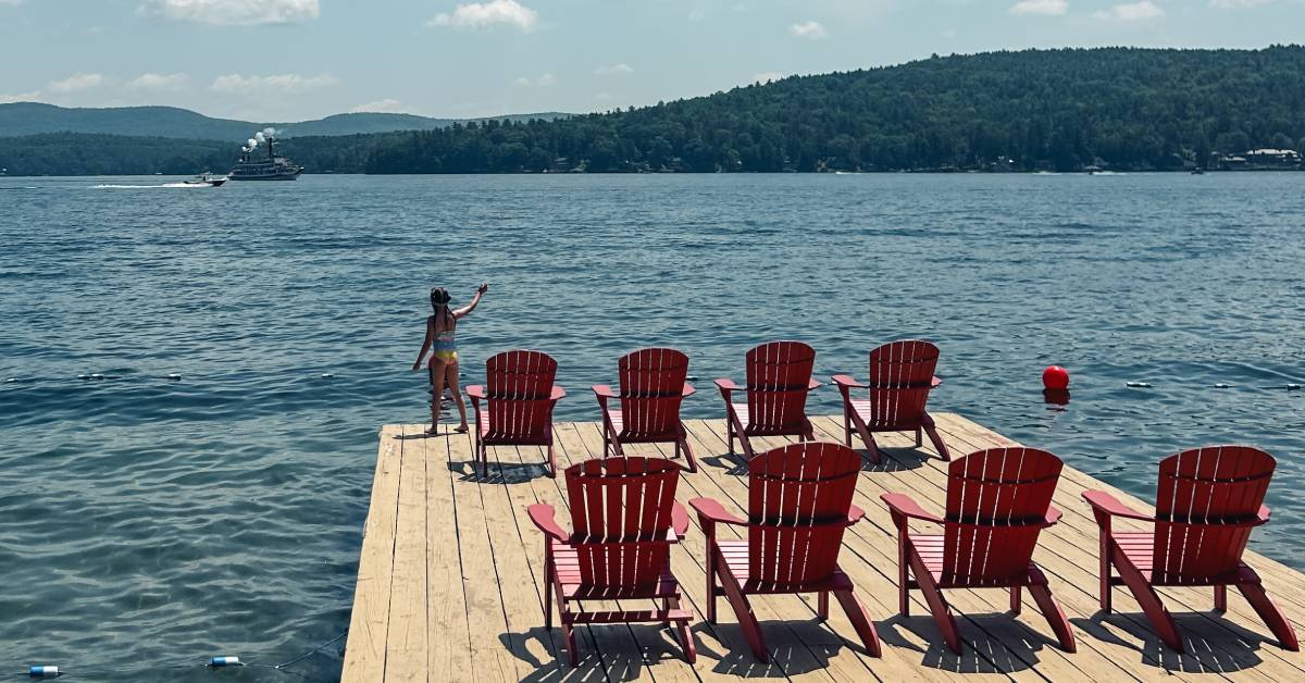 little girl on dock waves at steamboat