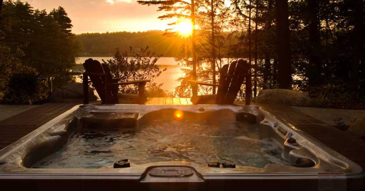 outdoor hot tub overlooking lake at sunset