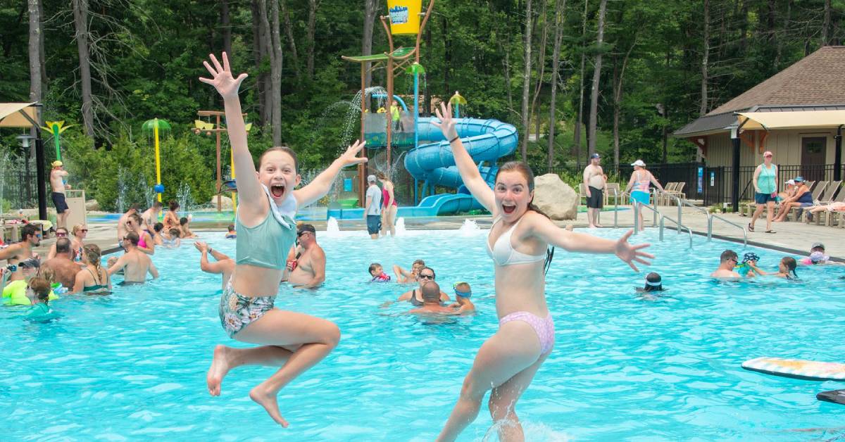 two young girls jumping into lake george rv park swimming pool excitedly