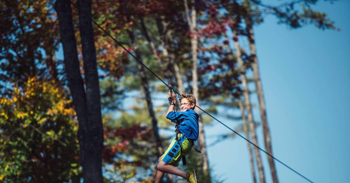 Boy ziplining through the Autumn leaves 