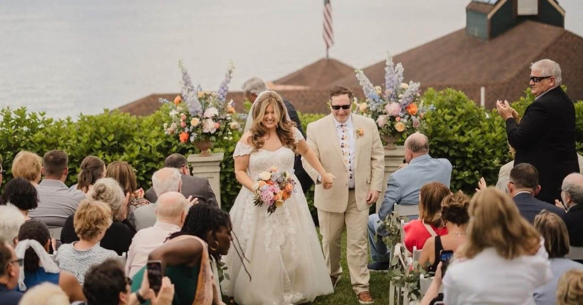 Couple walking down the aisle with guests on either side