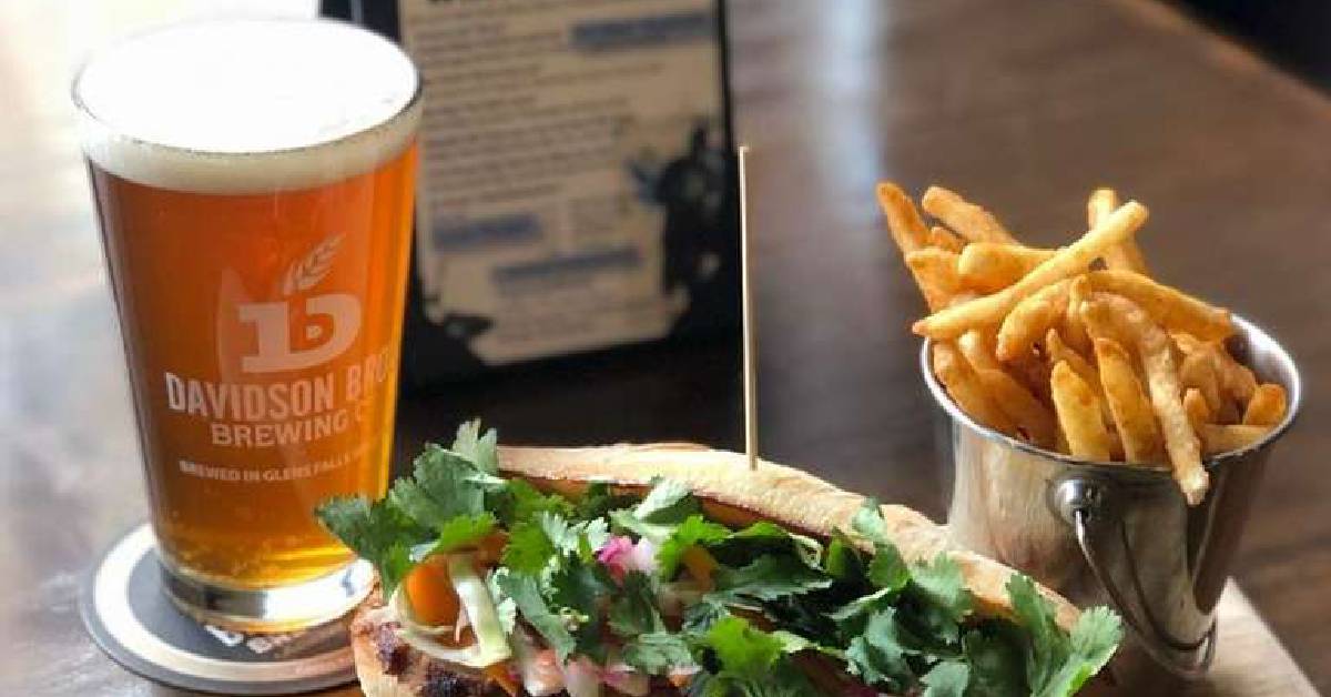 Beer and a sandwich with a side of fries