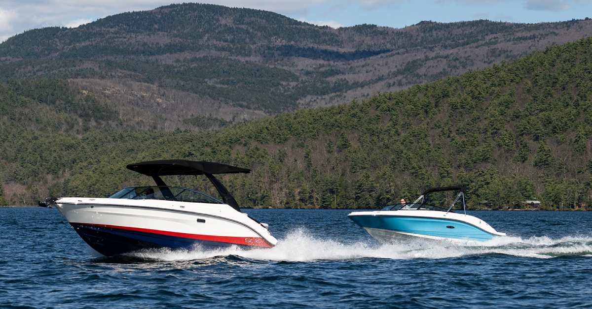 two motorboats on a lake with mountains in the background