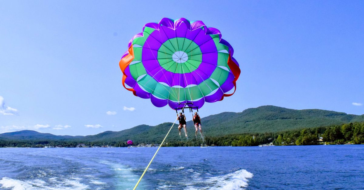 Two people parasailing over a body of water