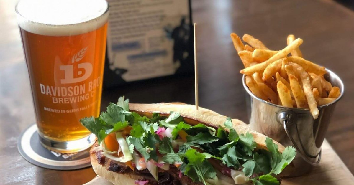 A sandwich, French fries, and craft beer in a Davidson Bro's glass