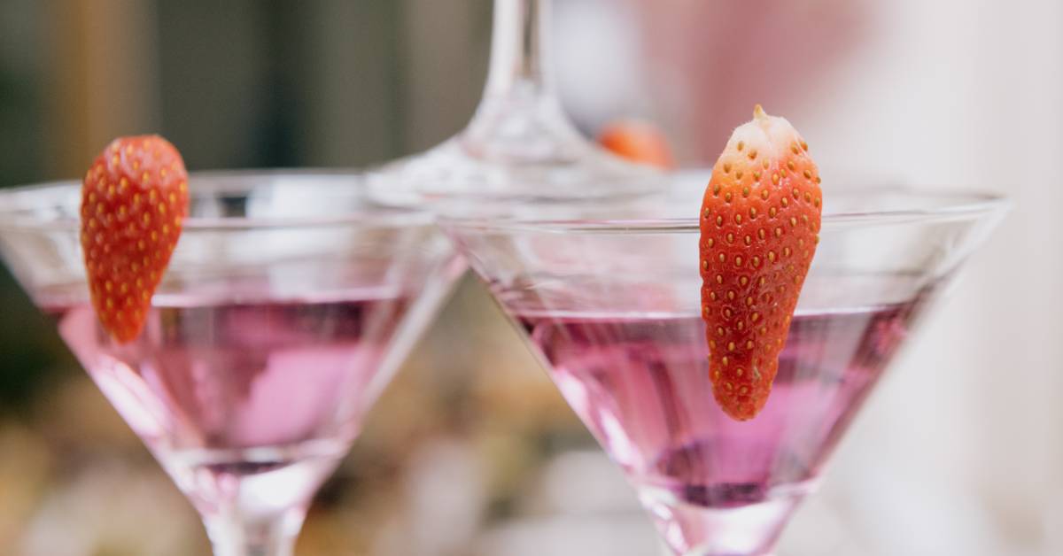 purple cocktails with strawberry garnish