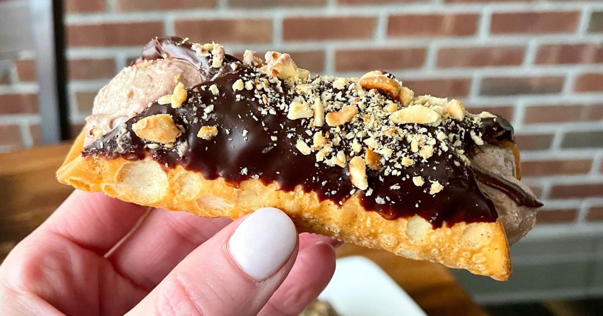 hand holding a cannoli