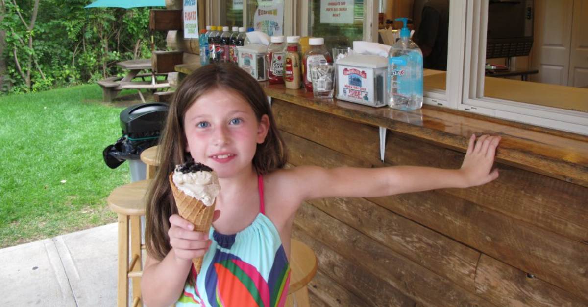 a girl holding up a waffle cone