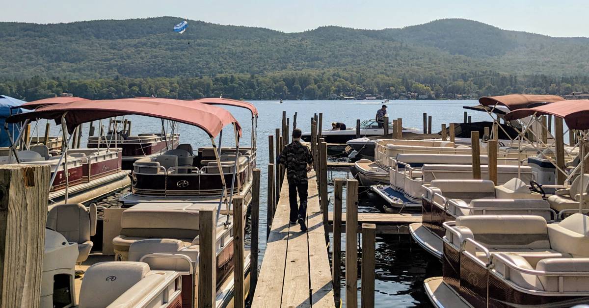man walks on dock between rows of boats
