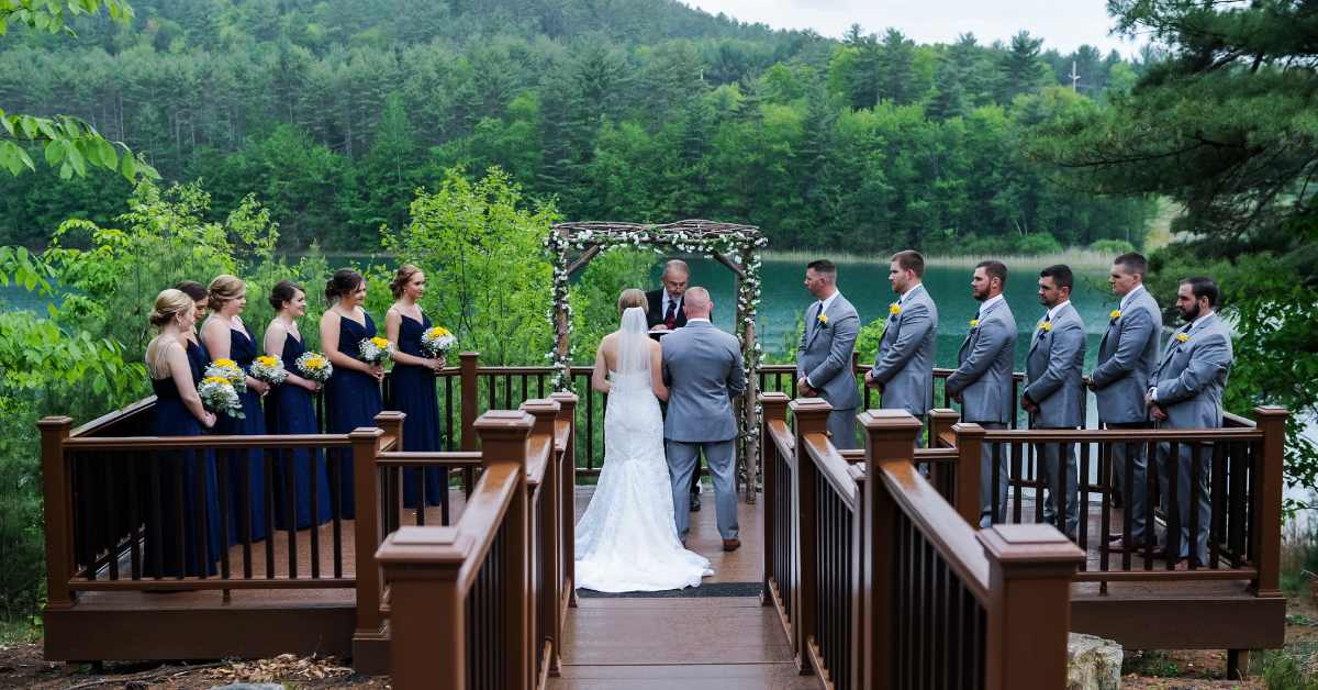 couple getting married by the waterfront with trees along the edge
