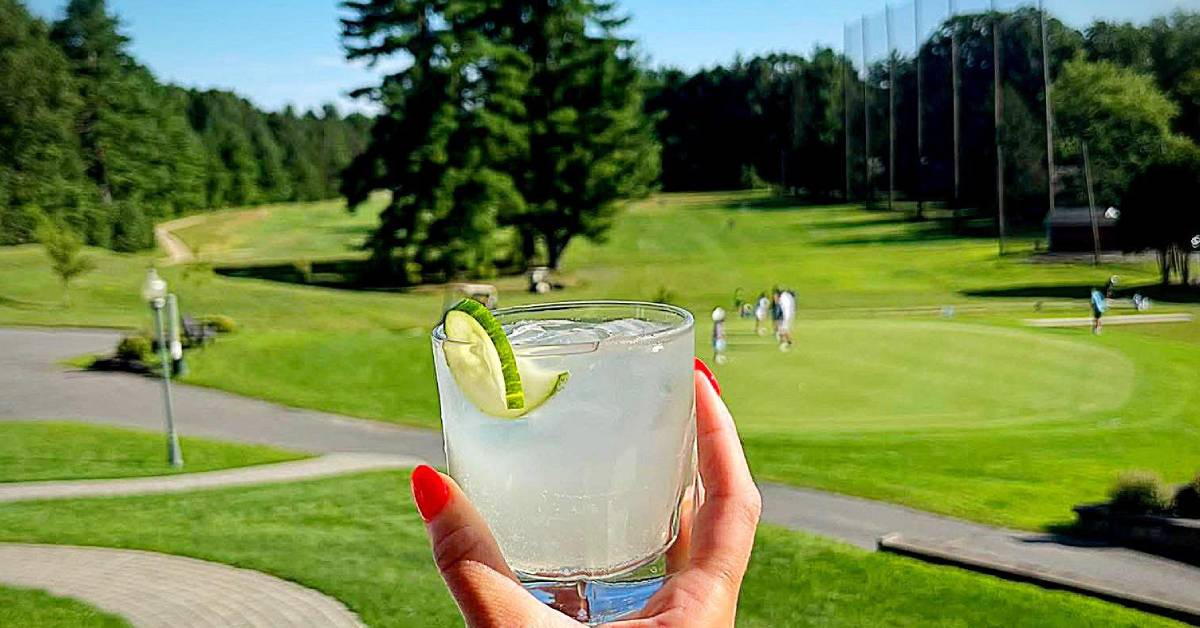 cocktail held up against mcgregor links country club golf course