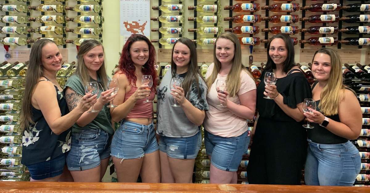 women by wall of wine for party