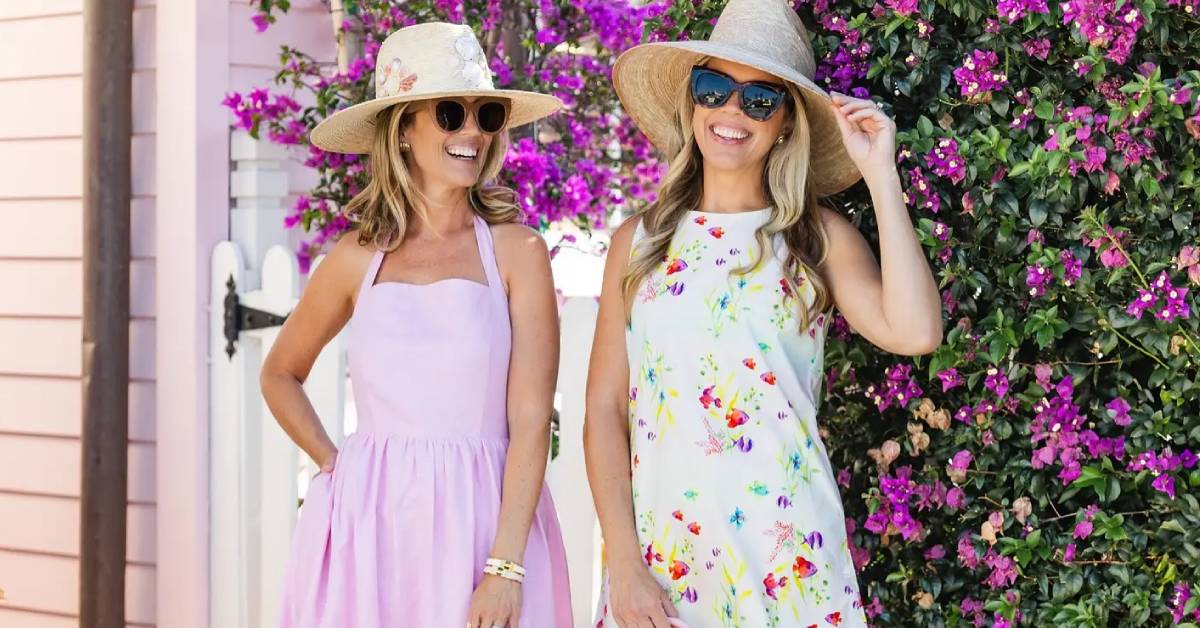 two fashionable women pose by flowers