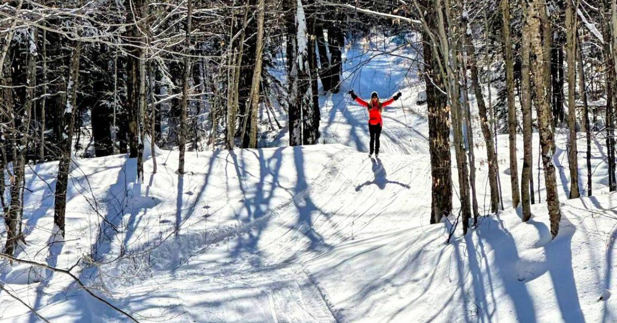 cross country skier poses on trail