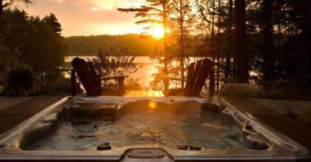 outdoor hot tub overlooking lake at sunset