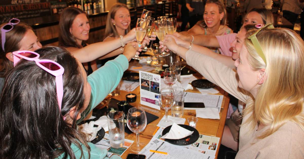 women cheersing with wines at a table