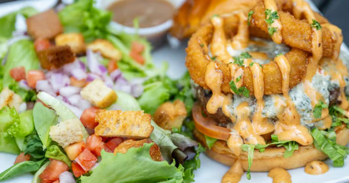 Image shows a glorious burger that guests love to enjoy when at Bailey's Cafe. 