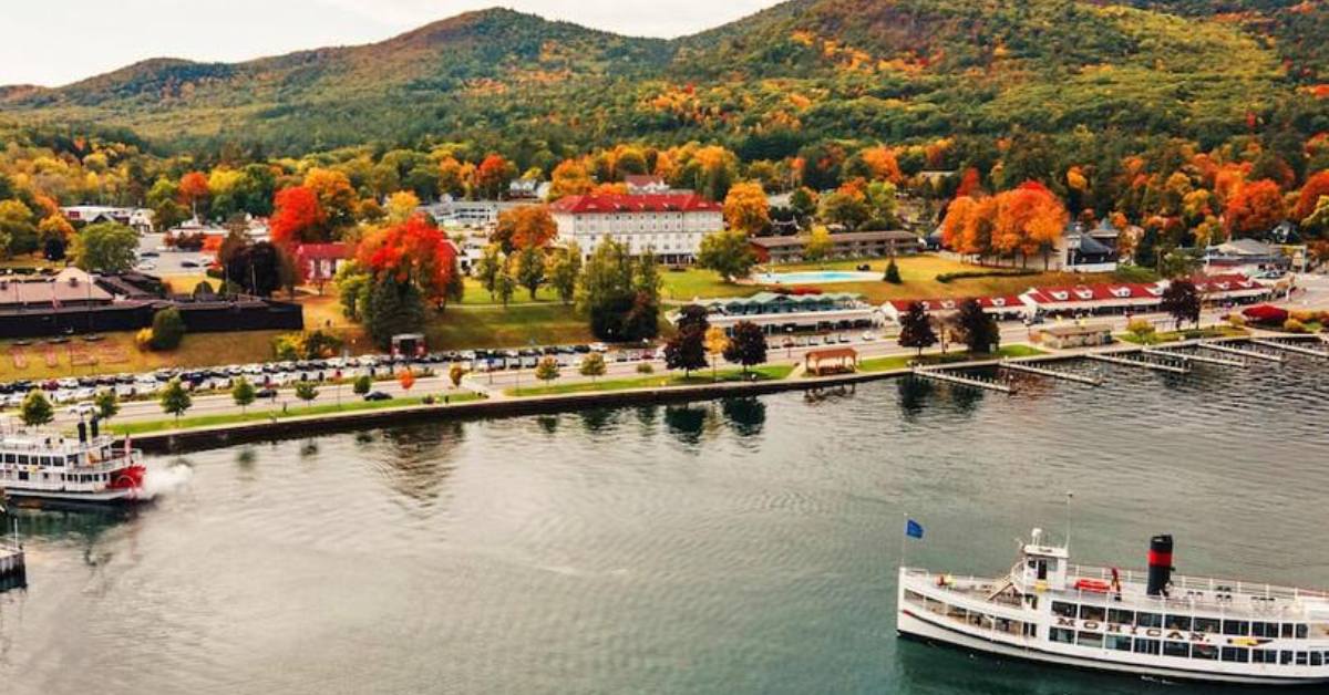 mohican ship on a lake with fall colors on trees near a hotel