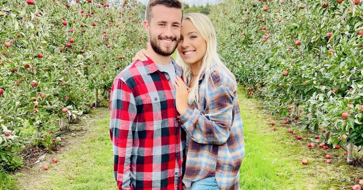 couple poses in apple orchard