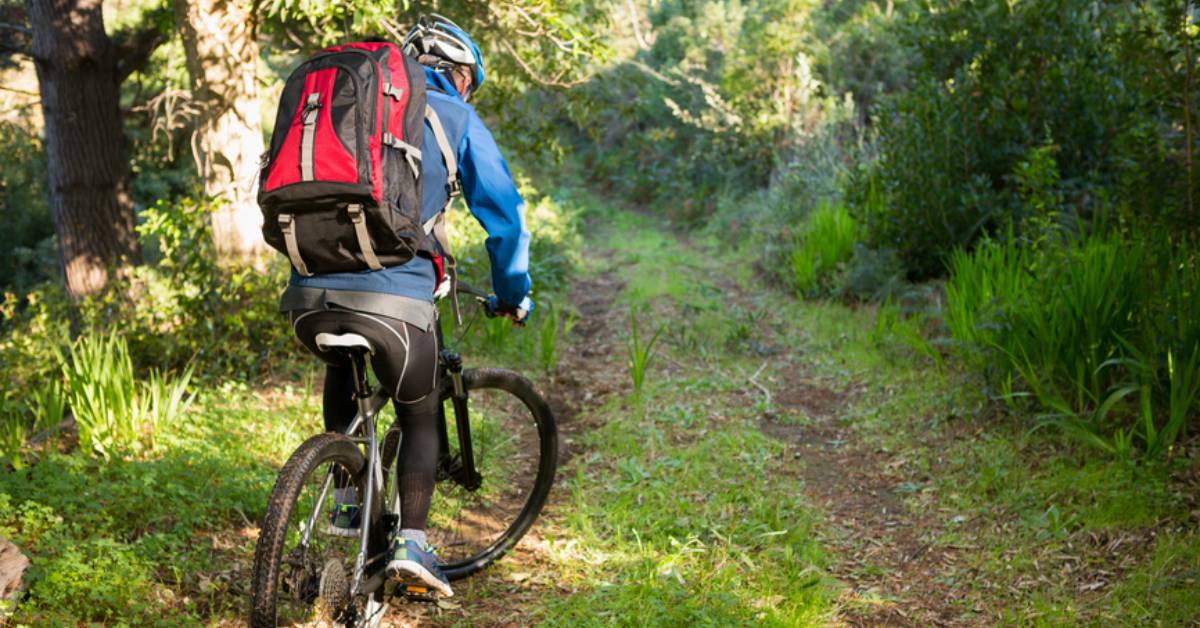 man on bike on trail in woods