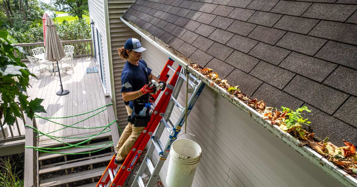 man cleaning gutters