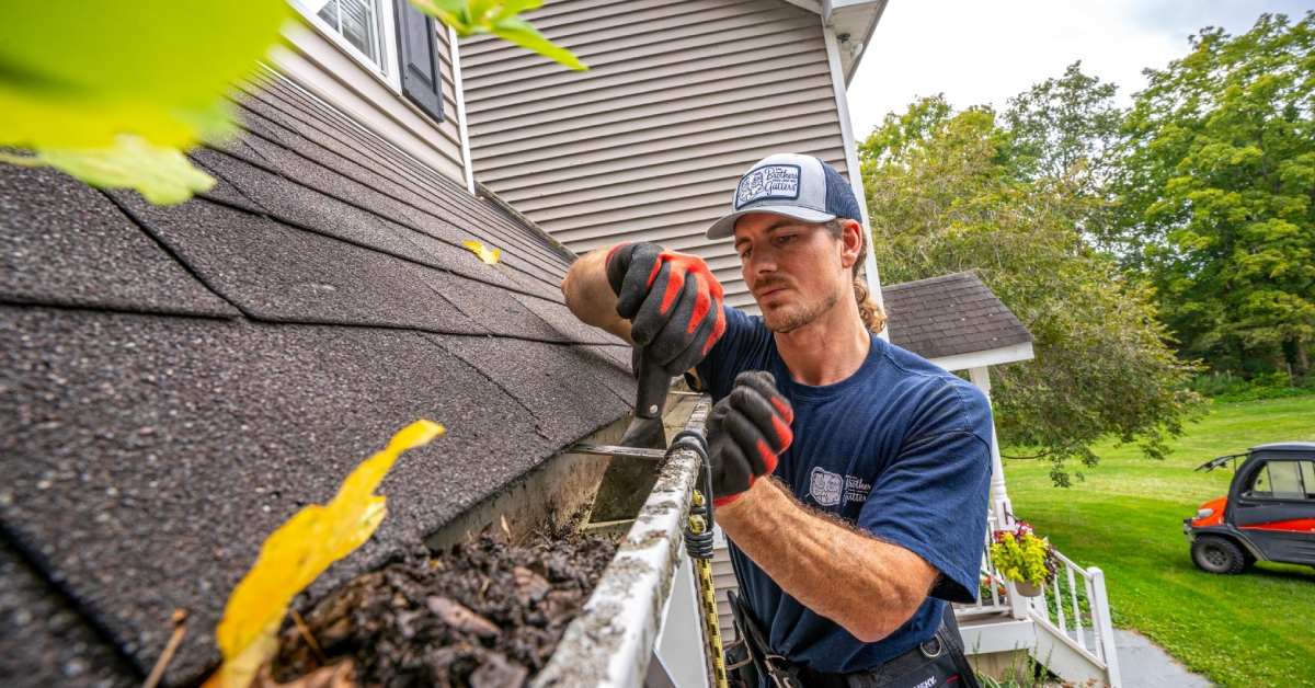 man cleaning gutters