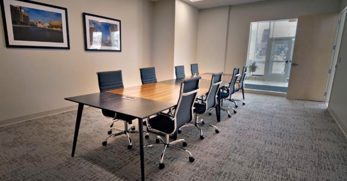 a small conference room with a long table and rolling chairs