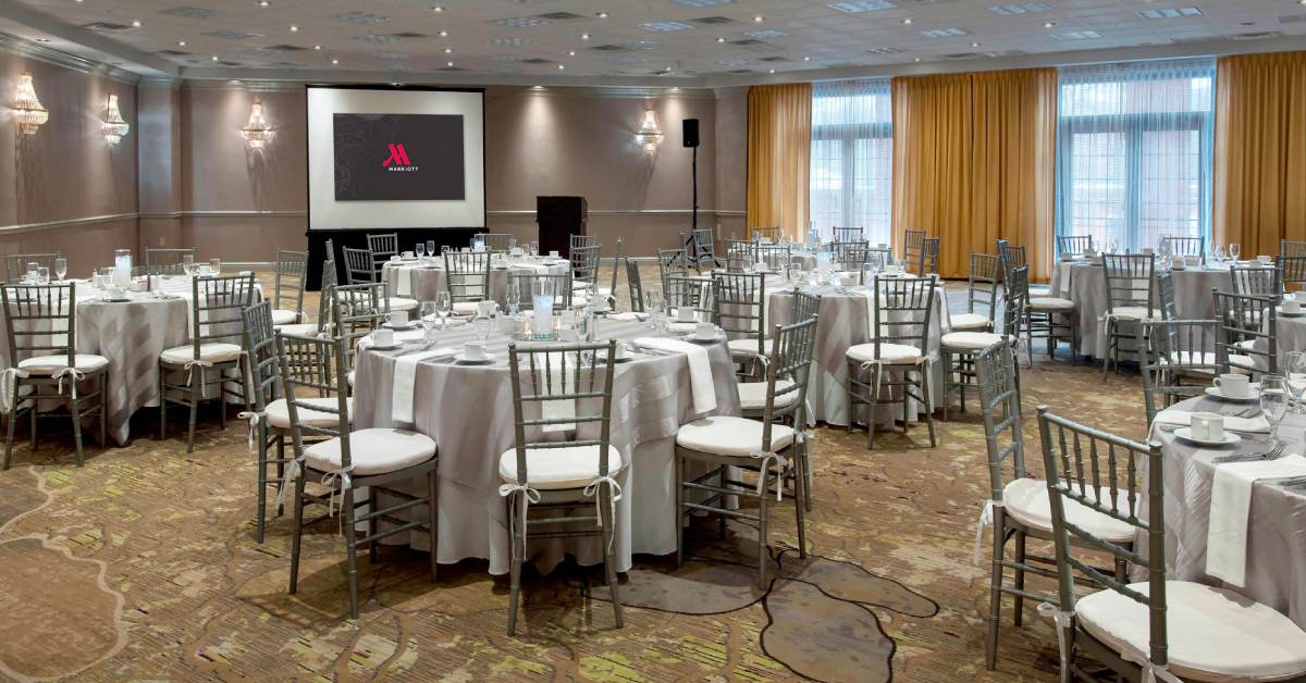 circular tables in a business meeting space with chairs and screen