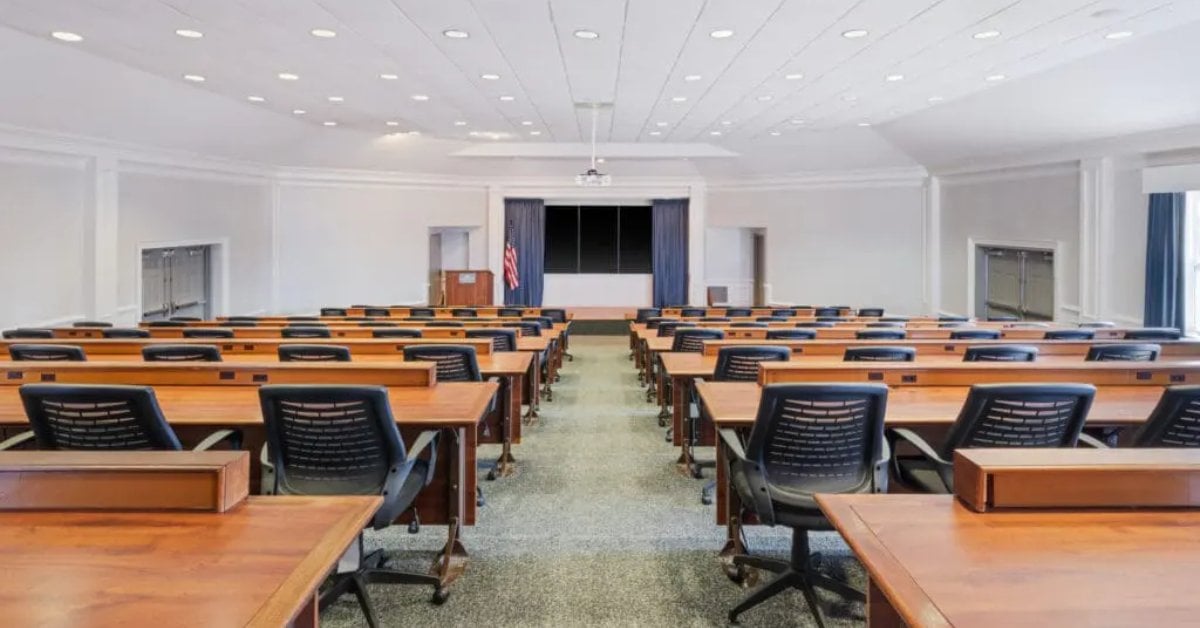 rectangular tables and black chairs set up in a business meeting space