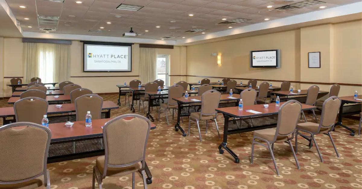 tables in a conference room with two screens
