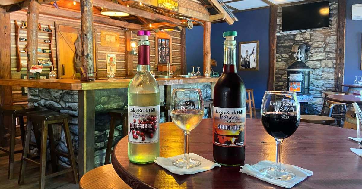 wine bottles and glasses on a table in a rustic winery