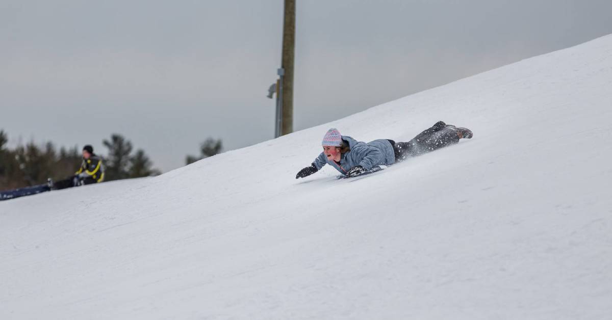 girl sledding on her stomach