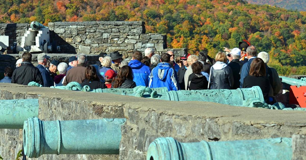 crowd of people near cannons at fort ticonderoga in the fall