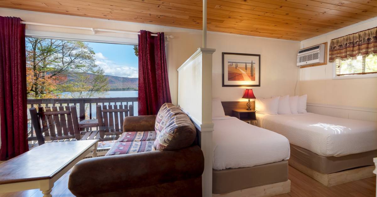 room and living room area with window looking out to fall foliage on lake