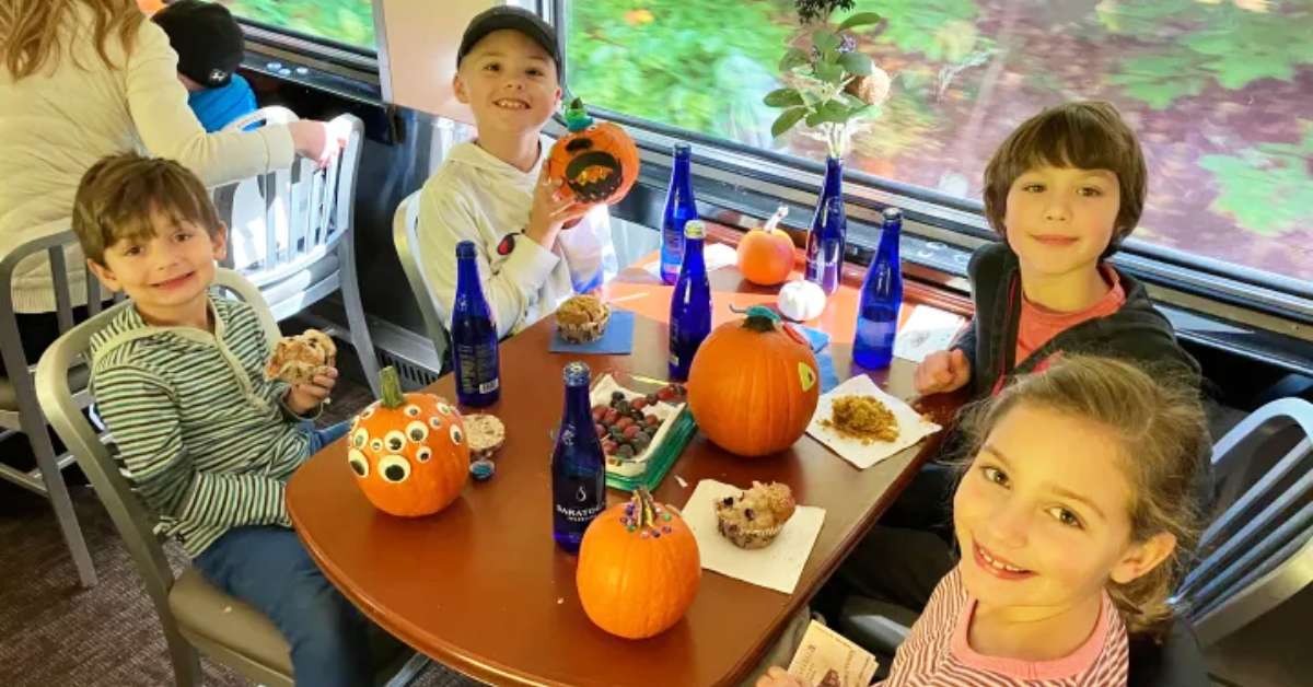 kids with decorated pumpkins on a train
