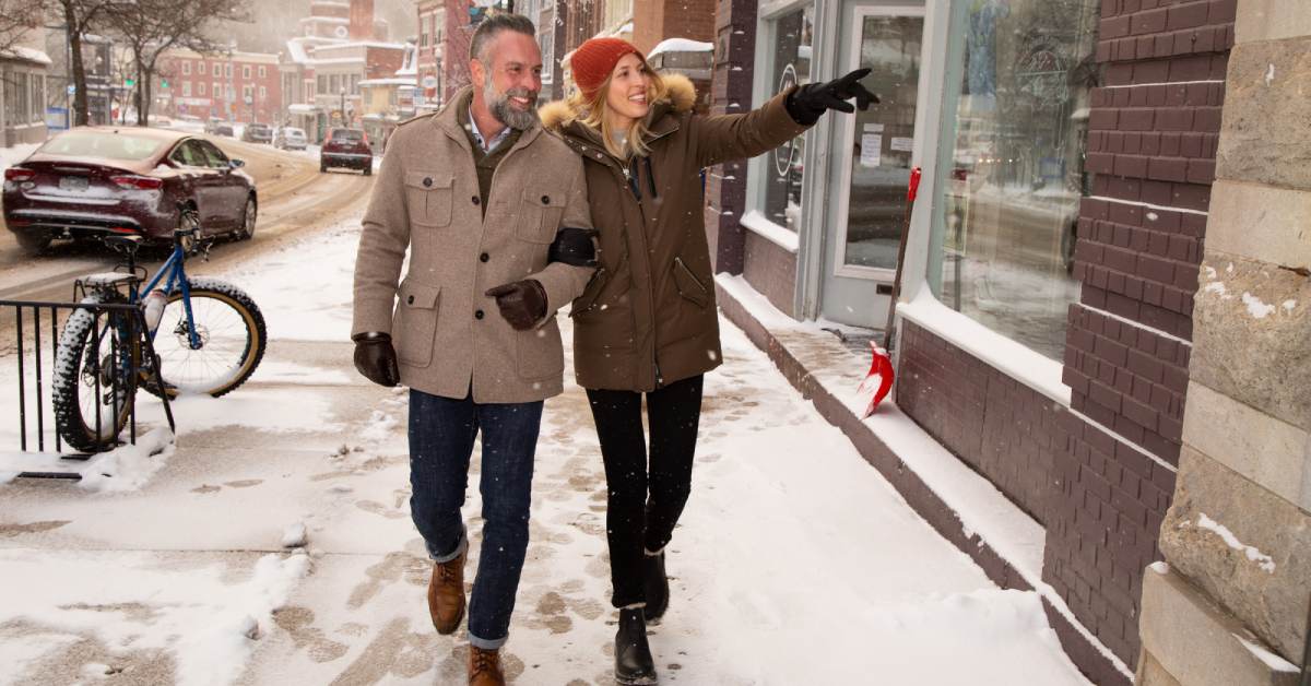 man and woman walking down sidewalk in winter