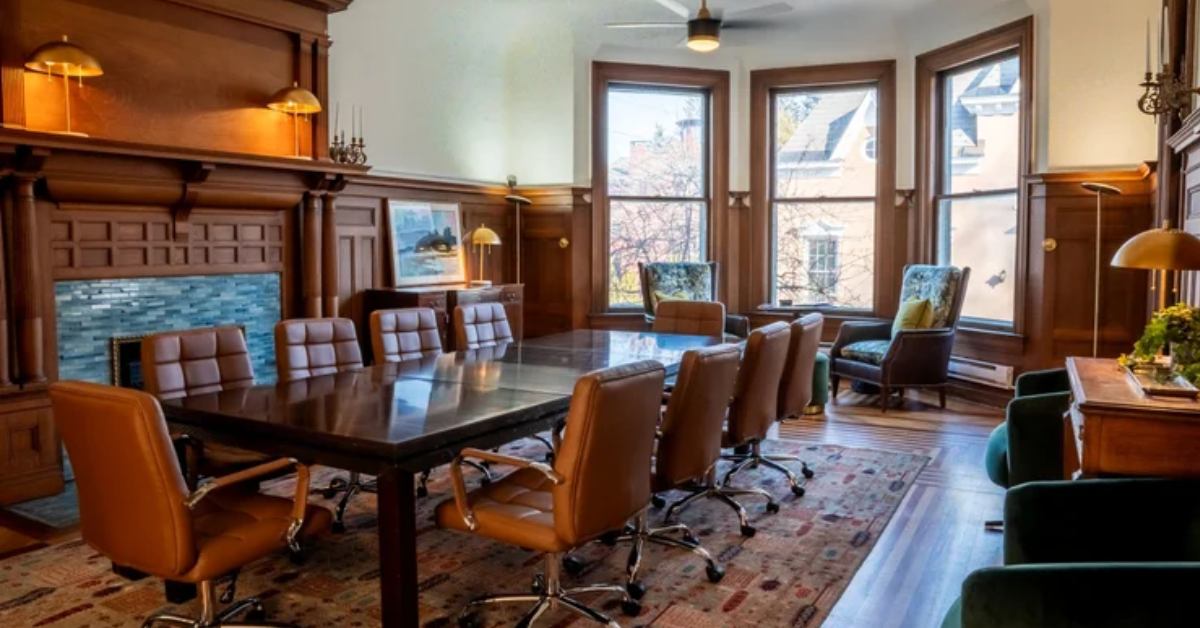conference room with large windows and a large table with leather chairs