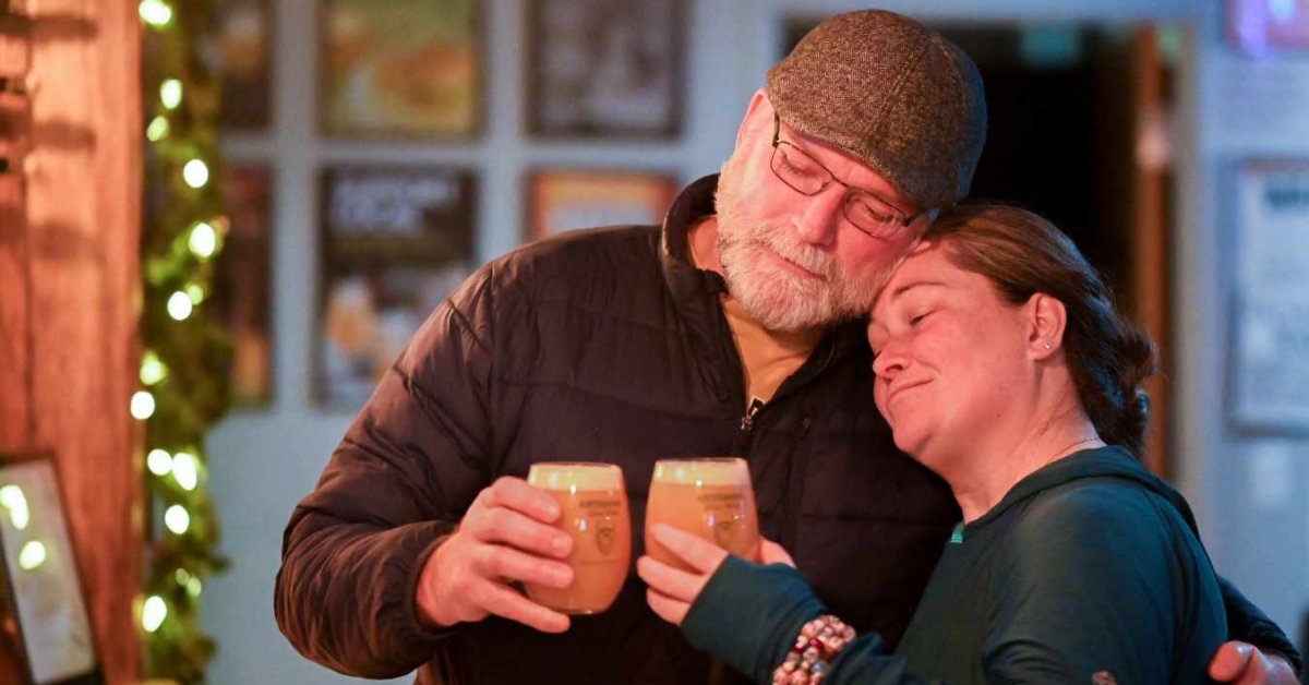 a couple embracing with beers