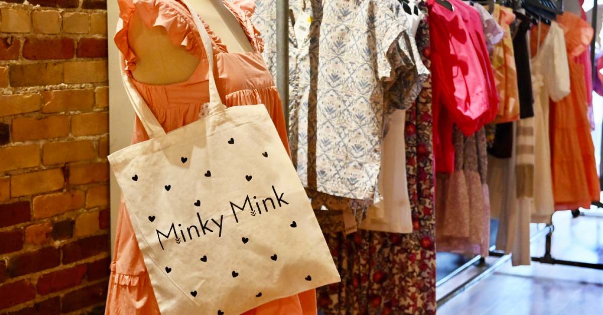 women's clothes and a bag for Minky Mink on a clothing rack