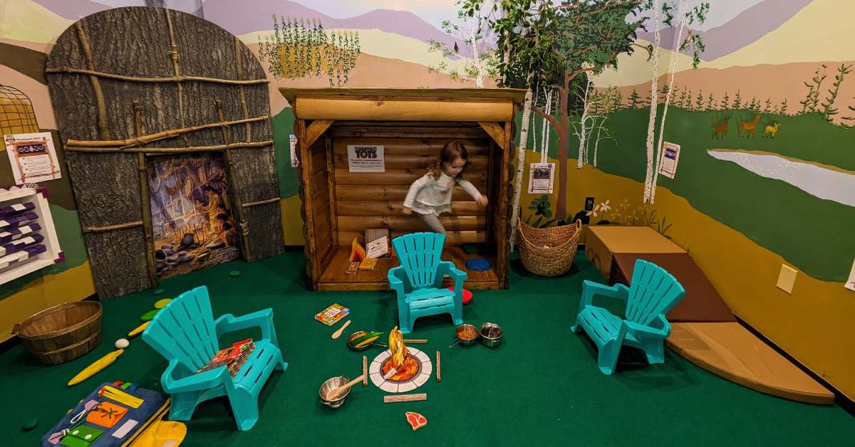 a girl exploring a kids display in a museum