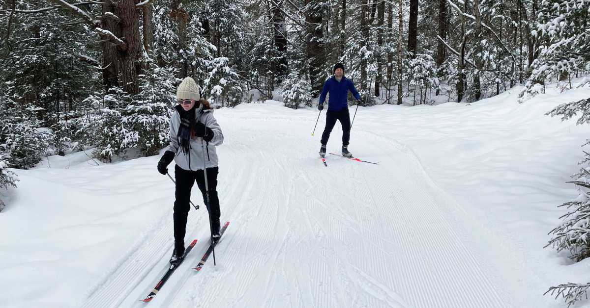 a man and woman cross country skiiing