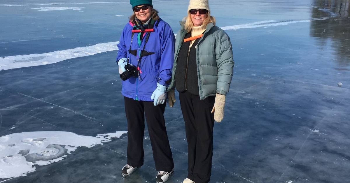 two women on ice skates on frozen lake